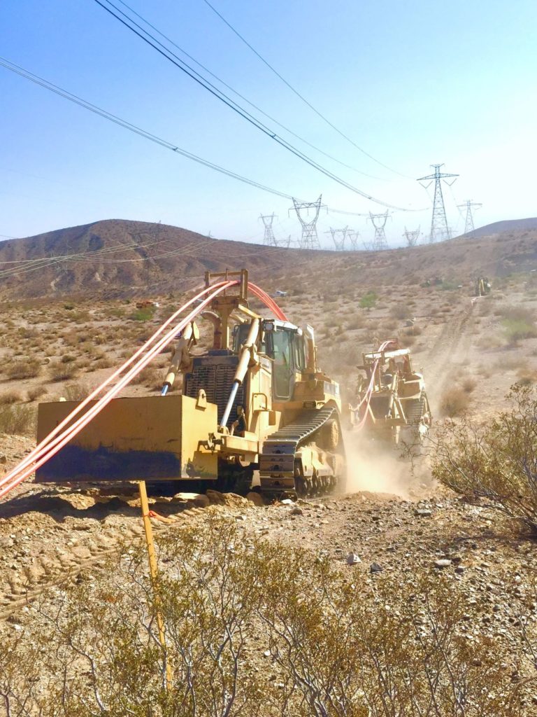 dozer tractors ploughing conduit for fiber optic line