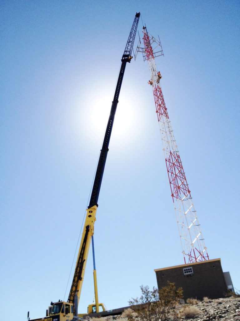 Communications tower construction with crane